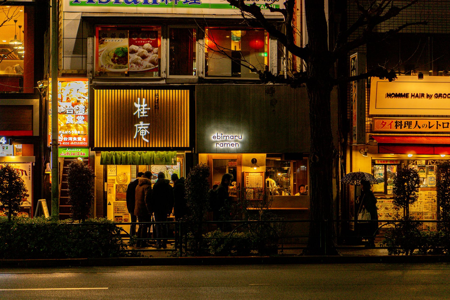 The lit shopfront of Nima & Nonna on Fortess Road at night, with a dark painted facade and warm light through the window